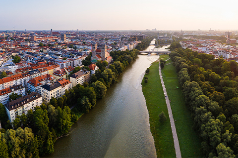 Vista aérea de Munique com um rio, árvores e um percurso pedestre ao longo do rio.