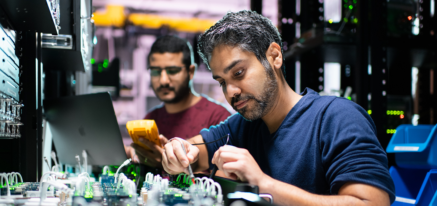 Dois engenheiros da Apple trabalham em componentes do iPhone num laboratório