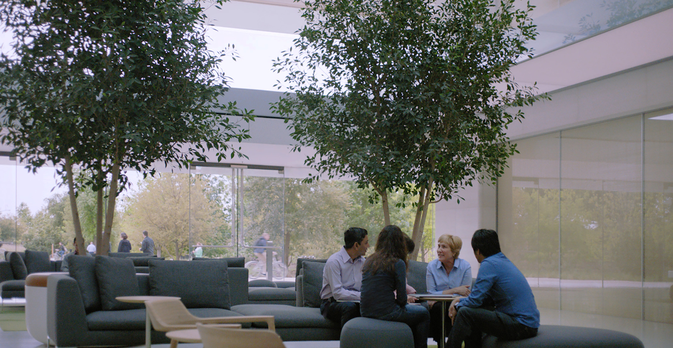 Giulia, que lidera uma equipa de processamento de linguagem natural, está sentada a uma mesa juntamente com outros funcionários da Apple.