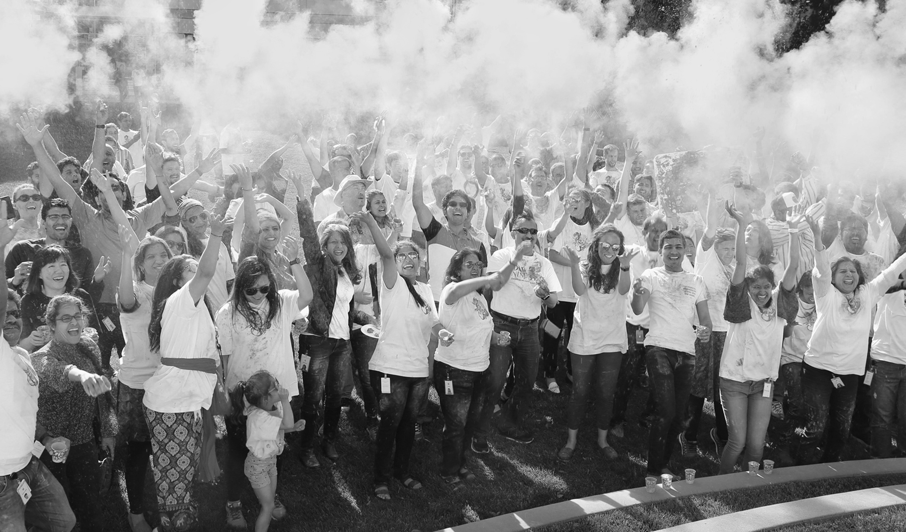 Foto de um grupo grande de funcionários comemorando na área externa de um campus da Apple.