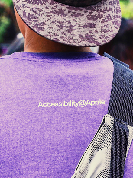 ภาพถ่ายคนคนหนึ่งจากด้านหลัง สวมเสื้อยืดที่มีคำว่า "Accessibility@Apple"