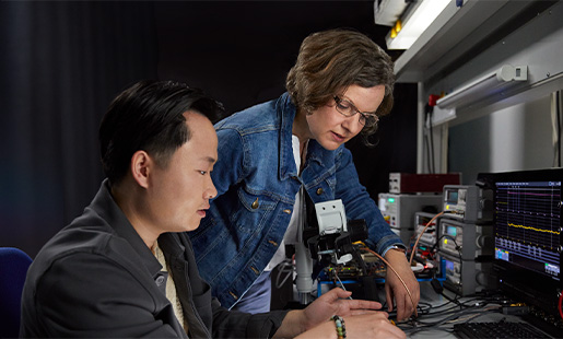 Ruth współpracująca przy stole laboratoryjnym z innym pracownikiem. Wspólnie zajmują się technologią procesorów.