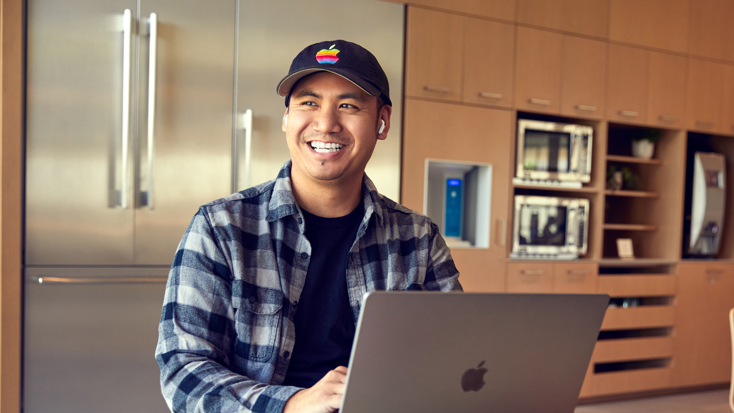Funcionário da Apple San Diego sorrindo e trabalhando em seu laptop.