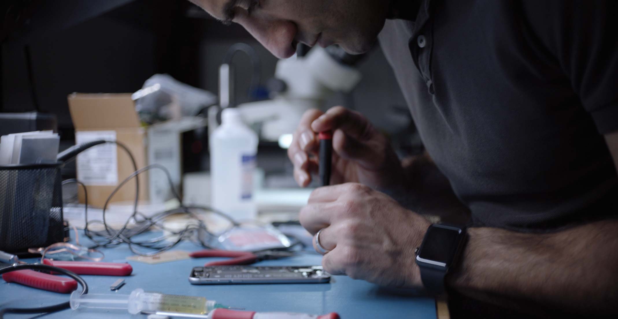 Ehsan, Engineering Manager van de Sensing Product Design-groep bij Apple, is bezig met een iPhone in een technisch laboratorium.
