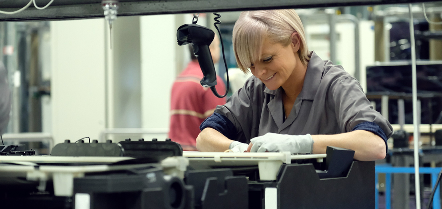 En una fábrica de Apple, dos empleados examinan las carcasas de aluminio de la MacBook en racks de titanio anodizado